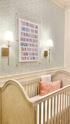 a baby crib in a room with two lamps on the wall