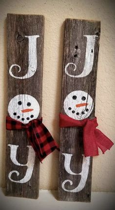 two wooden signs with snowmen on them hanging from the wall next to each other