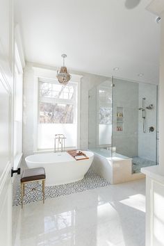 a bathroom with a large bathtub next to a walk in shower and a bench