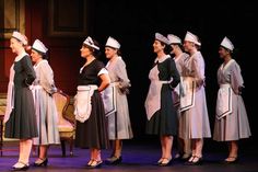 Sets of maid costumes in gray or hunter green with cotton or organdy aprons and hats. Theatre Costumes, Maid Costumes, Costume Shop