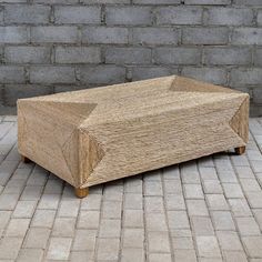 a wooden box sitting on top of a stone floor next to a brick wall in front of it