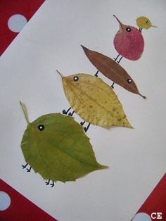 three leaf shaped birds sitting on top of a piece of paper next to polka dots