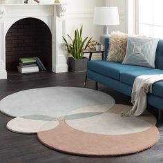 a living room with a blue couch and white rugs on the hardwood flooring