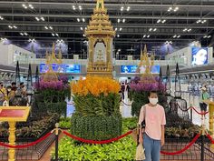 a man standing in front of a display of flowers and plants at an indoor plant show