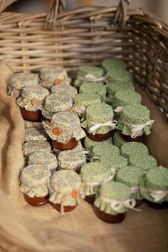small cupcakes sitting on top of a table next to a wicker basket