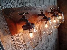 three mason jar lights are hanging on the wall