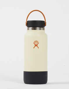 a white and black water bottle sitting on top of a white table next to a brown handle