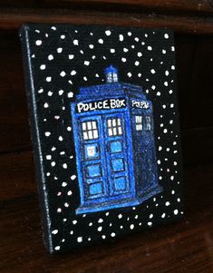 a painting of a blue police box on a wooden table