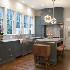 a large kitchen with wooden floors and gray cabinets