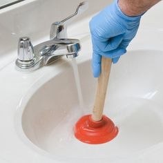 a person in blue gloves and rubber gloves is washing their hands with soap over a white sink
