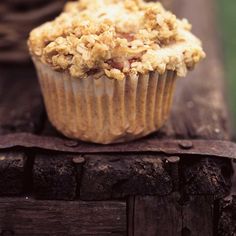 a close up of a muffin on top of a piece of wood