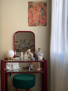 a desk with a mirror, stool and other items on it
