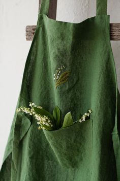 Traditional apron made from 100% soft and washed linen. Details:  - Hand embroidered lily of the valley - Composition: 100% Oeko-Tex certified linen - Colour: apple green - One large pocket - Adjustable with button - Size: One size. 85x65cm (33.5x25.5 inches) - Medium weight linen - Linen care: Boho, Couture, Linen Apron, Linen, Apron Designs, Green Apron, Linen Pinafore, Apron, Traditional Aprons