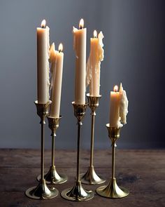 five candles are lined up in a row on a table with one candle lit and the other turned upside down