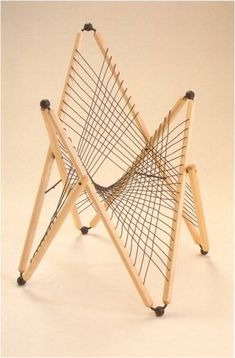 a chair made out of wooden sticks with wheels on the bottom and one leg up