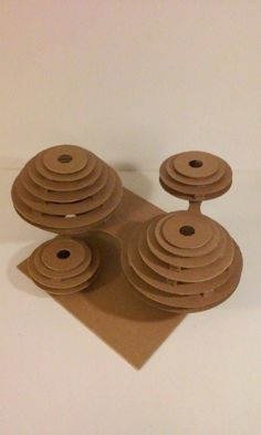 three pieces of brown paper sitting on top of a white tablecloth covered in circles