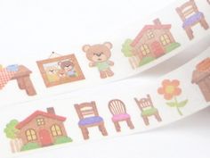 a roll of white washi tape with small cartoon bears and houses on the side