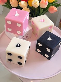 four dices are sitting on a table with tulips in the background