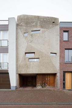 two bikes are parked in front of an apartment building with three storyed buildings on either side
