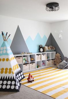 a child's playroom with mountains painted on the wall