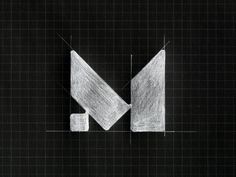 the letter m is drawn in white chalk on a black background with grids and lines