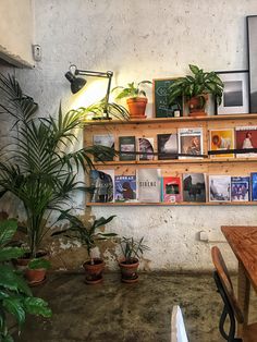 there are many plants and books on the shelves