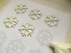 snowflakes are cut out and placed on paper