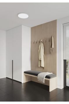 a coat rack with two coats hanging on it next to a bench in a room