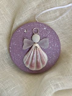 a purple and white shell ornament with a star in the middle on a linen background