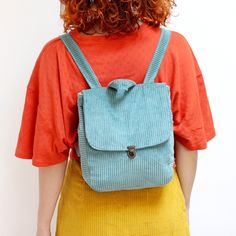 a woman with red hair wearing a blue backpack
