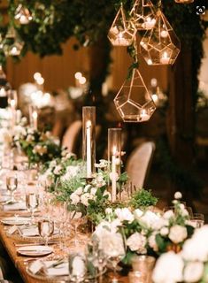 a long table with candles, flowers and greenery is set for an elegant dinner