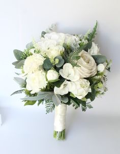 a bridal bouquet with white flowers and greenery