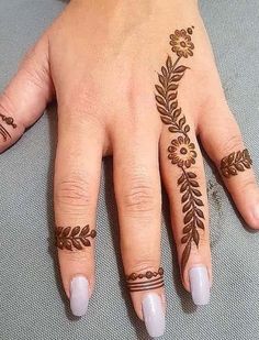 a woman's hand with hennap and flowers on her left hand, which is