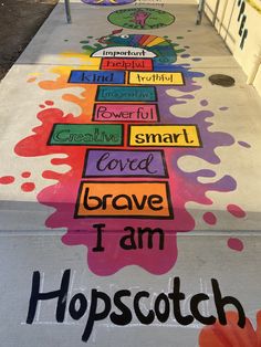 the sidewalk has been painted with different colors and words, including words that spell i am hopscotch