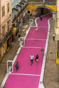people walking down a pink walkway in the city