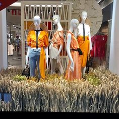 three mannequins dressed in orange and black outfits stand next to each other