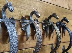 several metal horse head hooks mounted on a wooden wall