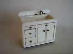a white toy sink with two drawers and a faucet in the middle is shown