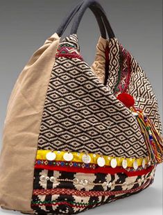 a handbag is shown with buttons and beads on the handles, along with a zippered closure