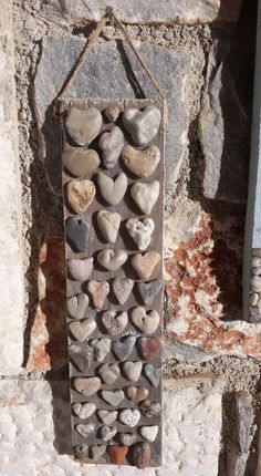 a stone wall hanging with hearts on it