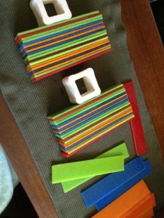 the toy is made from construction paper and plastic blocks, which are stacked on top of each other