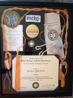 an award plaque is displayed in a black frame with orange tassels and other items