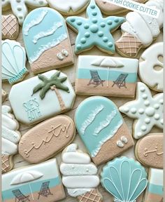 some cookies are decorated with blue and white icing on top of each other in the shape of beach scenes