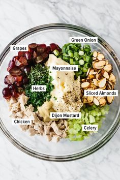 a glass bowl filled with different types of food on top of a marble countertop