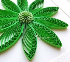 a green flower made out of paper sitting on top of a table