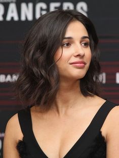 a close up of a person wearing a black dress and looking off to the side