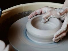 a person making a pot on a potter's wheel with their hands in it
