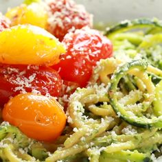 pasta with tomatoes, zucchini and parmesan cheese in a white bowl