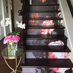 the stairs are painted with flowers on them and there is a vase full of flowers