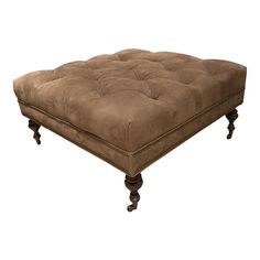 a brown ottoman sitting on top of a wooden table